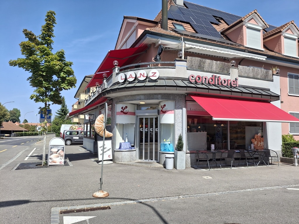 Bäckerei von aussen mit Sitzplätzen vom Bistro vor dem Laden
